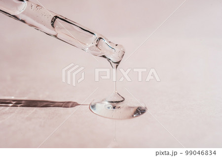 A drop of cosmetic oil falls from the pipette 99046834