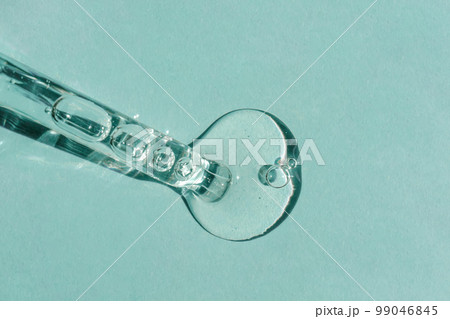 A drop of cosmetic oil falls from the pipette 99046845