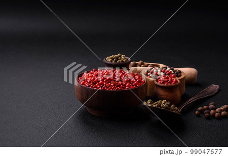 Composition, concept, consisting of several types of different colors of allspice in bowls and spoons 99047677