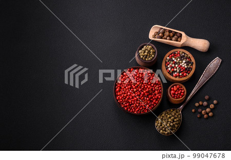 Composition, concept, consisting of several types of different colors of allspice in bowls and spoons Composition, concept, consisting of several types of different colors of allspice in bowls and spoons 99047678