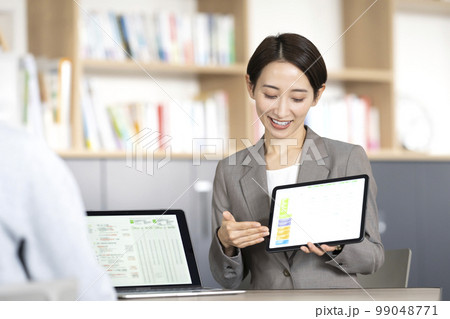 タブレットを使い説明するビジネスウーマン 99048771
