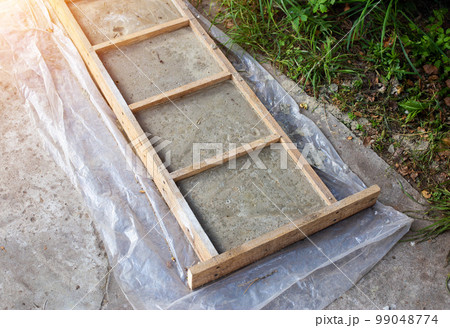The shape and pouring of homemade tiles in the country for the track. Production of paving slabs. Industry. Copy spsce for text The shape and pouring of homemade tiles in the country for the track. Production of paving slabs. Industry. Copy spsce for text 99048774