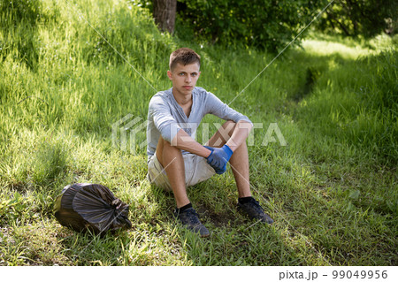 young man resting after cleaning the park 99049956
