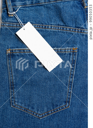 Back side pocket of blue jeans pants and price tag close-up background, mockup, copy space Back side pocket of blue jeans pants and price tag close-up background, mockup, copy space 99050353