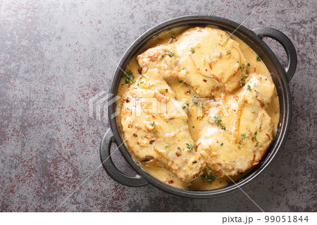 Fried spicy pork chops and then braised in creamy onion gravy closeup on the pan. Horizontal top view 99051844