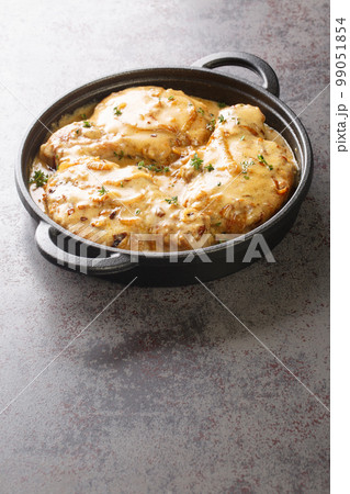 Creamy smothered pork chops seared and cooked in a rich onion gravy closeup on the pan. Vertical Creamy smothered pork chops seared and cooked in a rich onion gravy closeup on the pan. Vertical 99051854