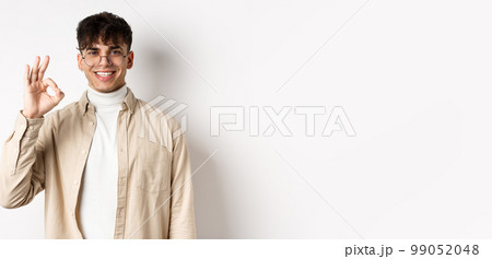 Image of handsome european man in glasses showing okay gesture, smiling satisfied, praise good quality, standing on white background Image of handsome european man in glasses showing okay gesture, smiling satisfied, praise good quality, standing on white background 99052048