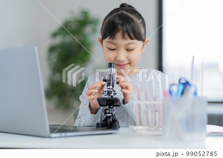顕微鏡を見る小学生の女の子 顕微鏡を見る小学生の女の子 99052785