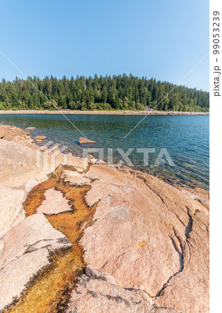 Mountain lake with a drop in the water level in times of drought. 99053239
