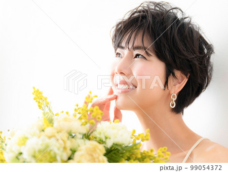 ウェディングや前撮り、美容イメージに使えそうな幸せいっぱいのミモザの花束を抱える可愛らしい女性 ウェディングや前撮り、美容イメージに使えそうな幸せいっぱいのミモザの花束を抱える可愛らしい女性 99054372