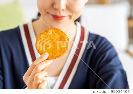 せんべいを食べる若い女性 99054407