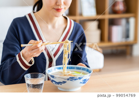 ラーメンを食べる若い女性 99054769