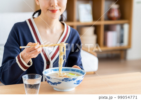 ラーメンを食べる若い女性 99054771