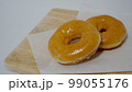 木の板にのせられたグレーズドドーナツ 99055176