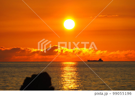 日没の夕日が反射する海と水平線、タンカーのシルエット 99055196