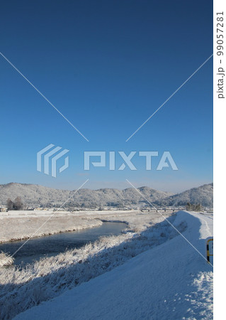 雪の朝の河川と青空 99057281