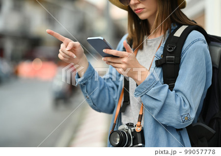 Young female tourist using smartphone platform applications for helping tourism about travel map GPS 99057778