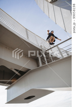 Man doing huge parkour jump from the bridge 99058198