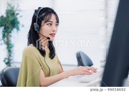 笑顔でお客様対応をする電話オペレーター 99058692