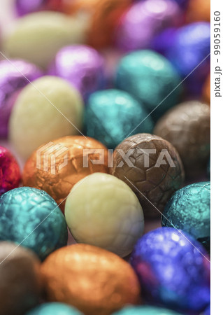 Big pile of colorful wrapped chocolate easter eggs, shiny festive Easter concept, Happy easter close-up candy sweets concept macro Big pile of colorful wrapped chocolate easter eggs, shiny festive Easter concept, Happy easter close-up candy sweets concept macro 99059160