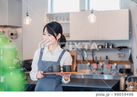 カフェのホールスタッフとして働く女性 99059496