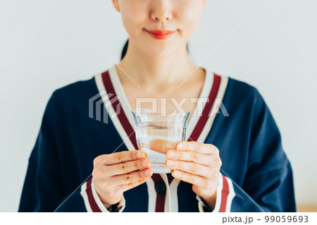 ミネラルウォーターを飲む若い女性 99059693