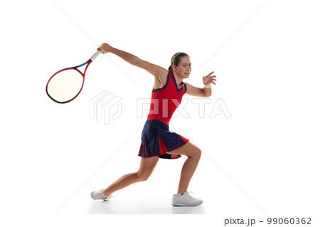Studio shot of active teen girl, professional tennis player training with tennis racket over white background. Sport, fashion, ad, action, motion, achievement concept Studio shot of active teen girl, professional tennis player training with tennis racket over white background. Sport, fashion, ad, action, motion, achievement concept 99060362