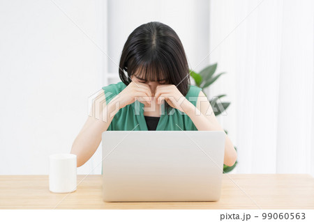 パソコンを使いながら泣いている若い女性 パソコンを使いながら泣いている若い女性 99060563