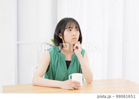 リビングで考え事をしている若い女性 99061651
