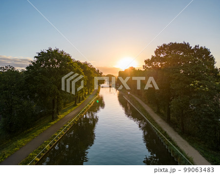 Beautiful sunset over a river with green bushes and color rich sky 99063483
