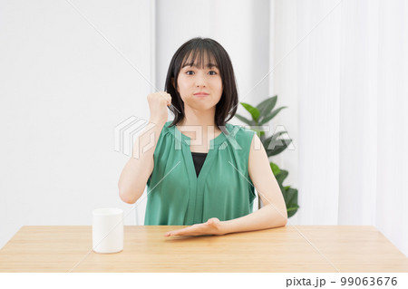 リビングで納得したポーズをする若い女性 99063676