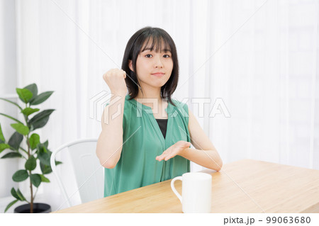 リビングで納得したポーズをする若い女性 99063680