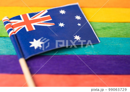 Australia flag on rainbow background flag symbol of LGBT gay pride month  social movement rainbow flag is a symbol of lesbian, gay, bisexual, transgender, human rights, tolerance and peace. 99063729