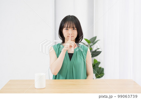リビングで内緒のポーズをする若い女性 リビングで内緒のポーズをする若い女性 99063739