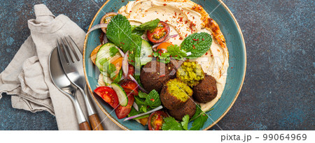 Middle Eastern Arab meal with fried falafel, hummus, vegetables salad 99064969
