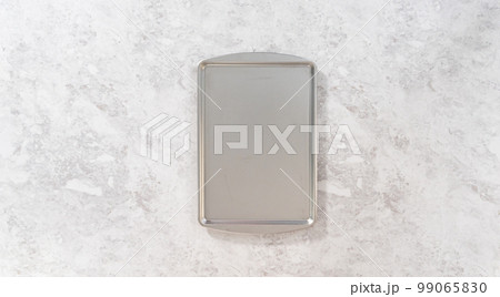 Flat lay. Piping melted chocolate from a piping bag over the parchment paper to make chocolate carrot cake toppers. Flat lay. Piping melted chocolate from a piping bag over the parchment paper to make chocolate carrot cake toppers. 99065830