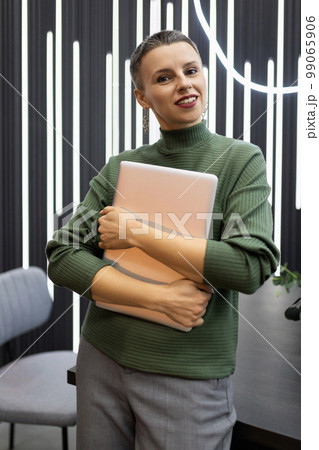 portrait of a successful mature female programmer against the backdrop of a stylish office portrait of a successful mature female programmer against the backdrop of a stylish office 99065906