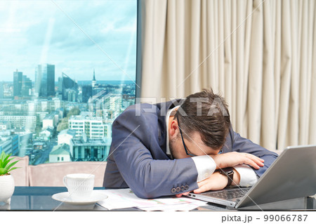 Tired man working at home office, Exhausted, stressed, overworked man, unsuccessful financial investments. Tired man working at home office, Exhausted, stressed, overworked man, unsuccessful financial investments. 99066787