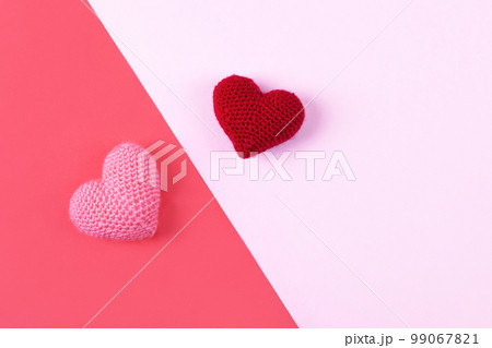 Croched pink and red hearts on a pink and red background. Valentine's Day, symbol of love. Croched pink and red hearts on a pink and red background. Valentine's Day, symbol of love. 99067821