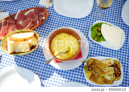 Traditional rustic treat in Montenegro. Prshut, vegetables, wine. Kachemak is a corn porridge mixed with crushed potatoes and kaymak, sheep cheese 99068018