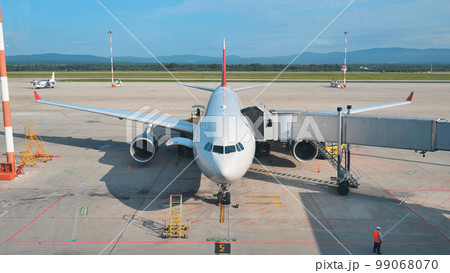 The plane at the airport is waiting for departure at the terminal. 99068070