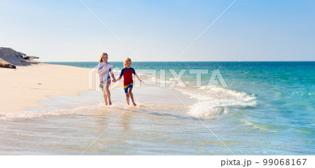 Kids playing on beach. Children play at sea. 99068167