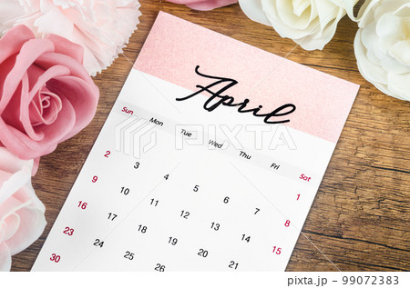 The April 2023 Monthly calendar for 2023 year with pink rose on wooden background. 99072383