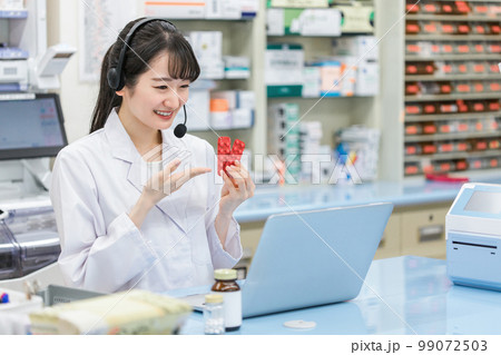病院・薬局でパソコンを使ってオンライン服薬指導・診療する薬剤師・調剤師の女性（処方箋・医師） 99072503