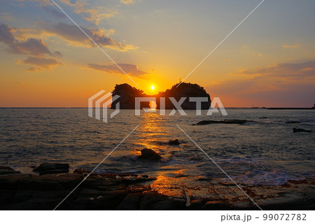 夕焼け空を背景にした円月島の海蝕洞に沈む夕日 夕焼け空を背景にした円月島の海蝕洞に沈む夕日 99072782
