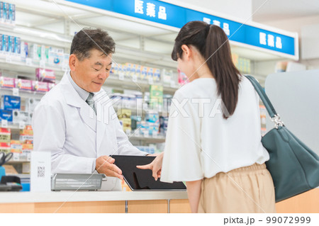 薬局・病院・ドラッグストアでタブレットPCを使って説明する薬剤師（処方箋・薬・サプリメント） 99072999