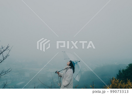 街バックに傘をさす女性の写真 99073313