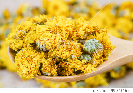 A Dried Chrysanthemum tea in wooden spoon 99073565