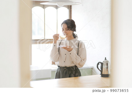 温かい飲み物を飲む女性 温かい飲み物を飲む女性 99073655
