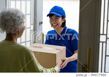 荷物を届ける若い女性 99077966